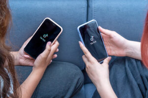 Personen schauen auf Handy mit Tik Tok